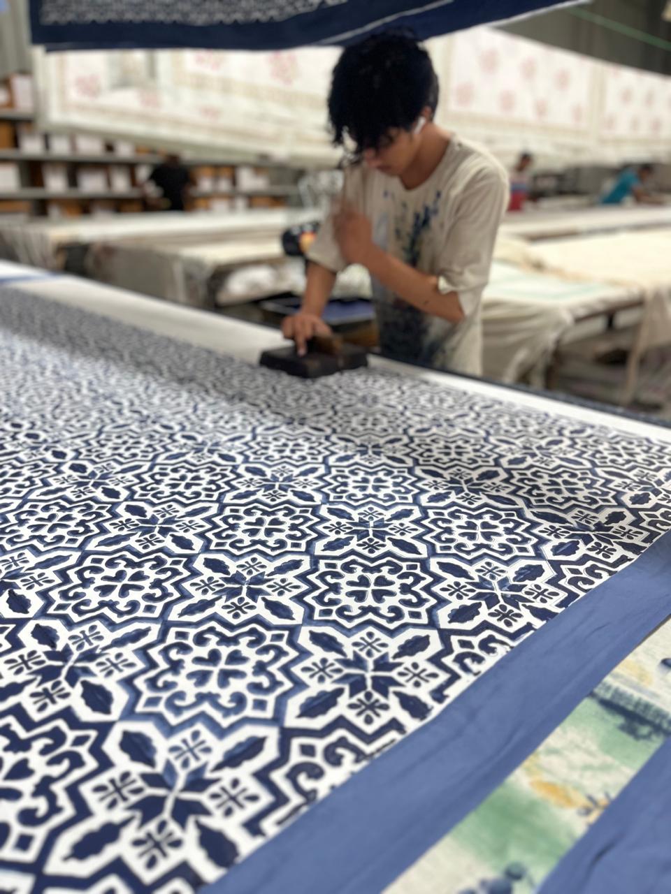Artisan block printing an indigo geometric pattern on cotton fabric