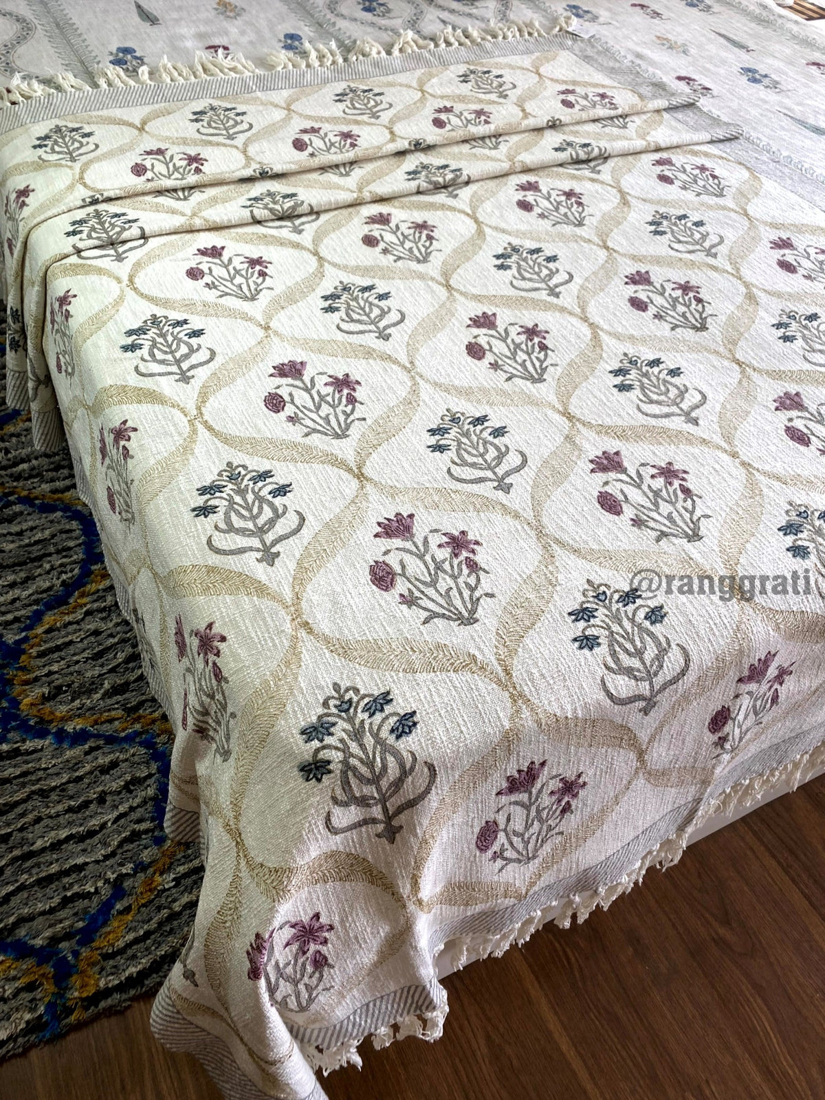 Blue And Pink Floral Jute Cotton Sofa Throw - draped on bed, side view