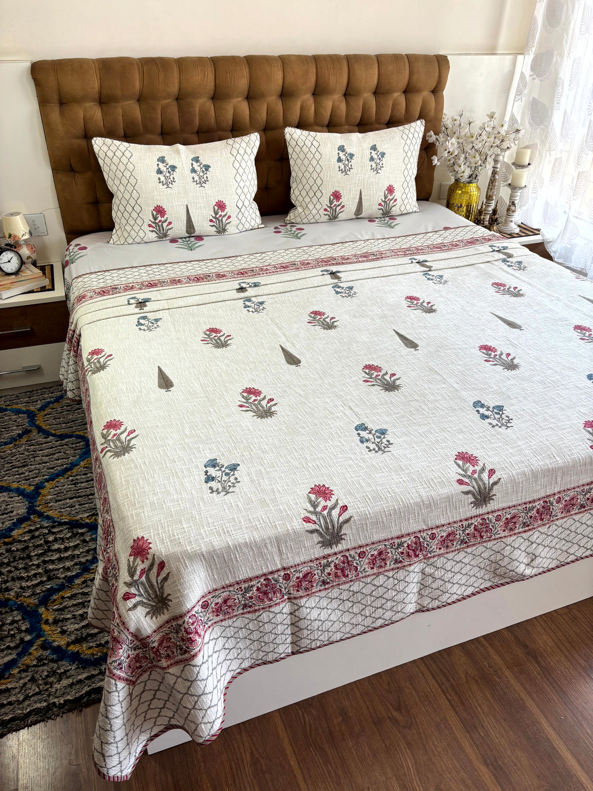 Gulistan Whisper ivory jute cotton king size bedcover with pink and blue floral hand block print and matching pillow covers.