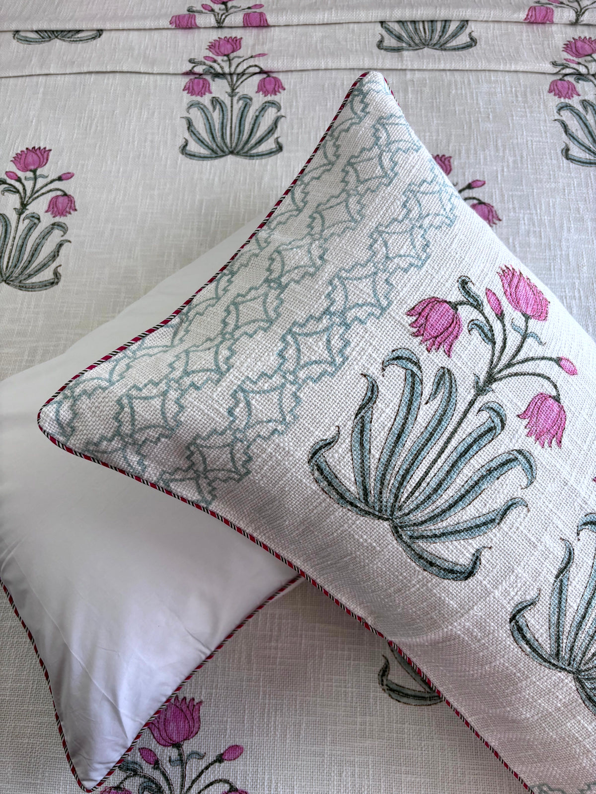 Matching Gulmohar Melody hand block printed jute cotton pillow covers with pink floral motifs and Jaipuri design.


