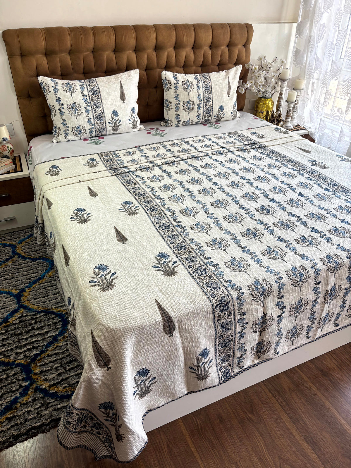 Full view of Neel Pushp Symphony ivory hand block printed jute cotton king size bedcover with indigo floral bouquet design.