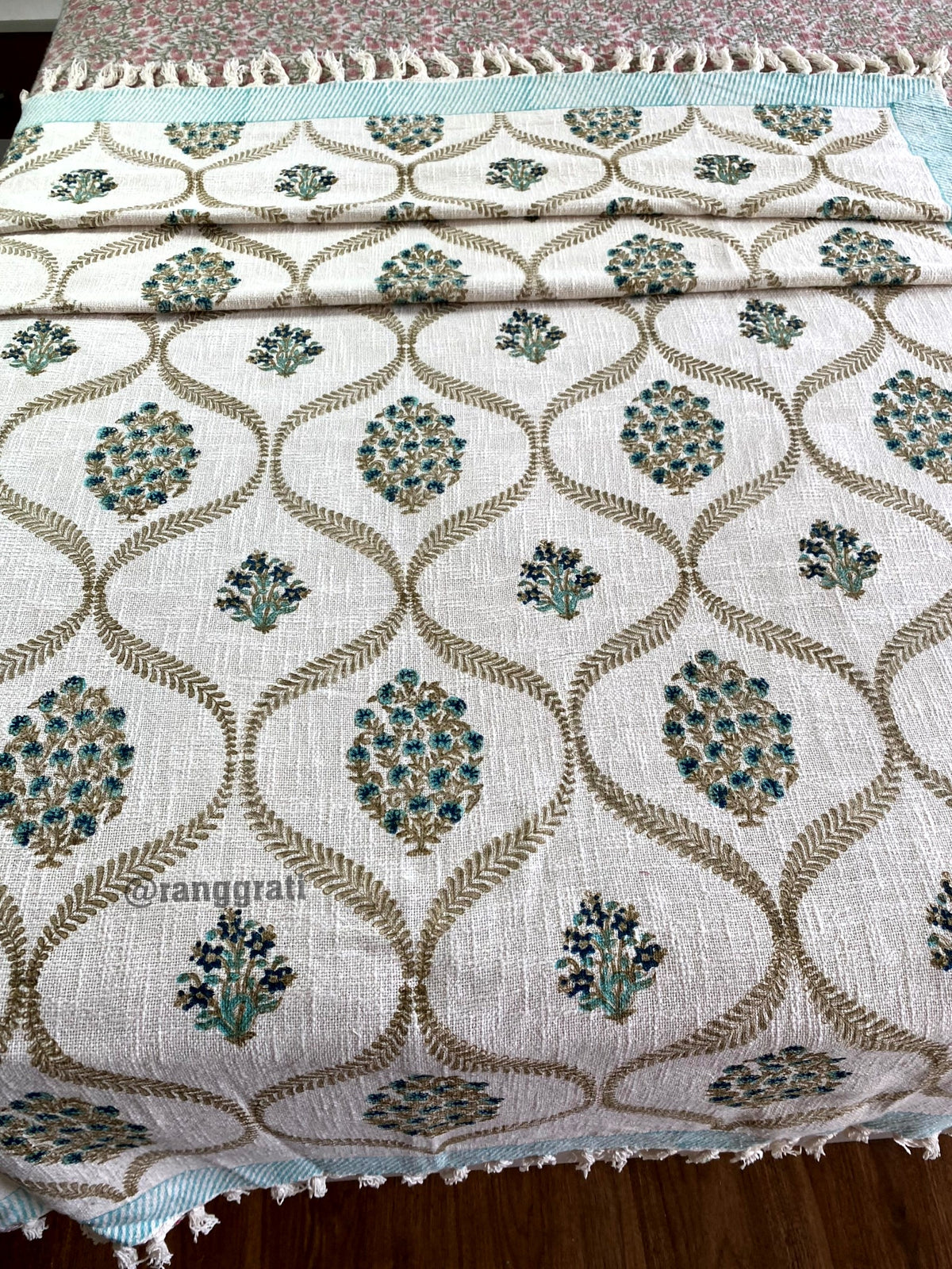 Turquoise Floral Hand Block Jute Cotton Sofa Throw - front view on bed